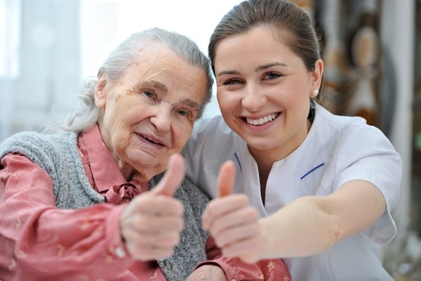Support worker with old lady in aged care facility